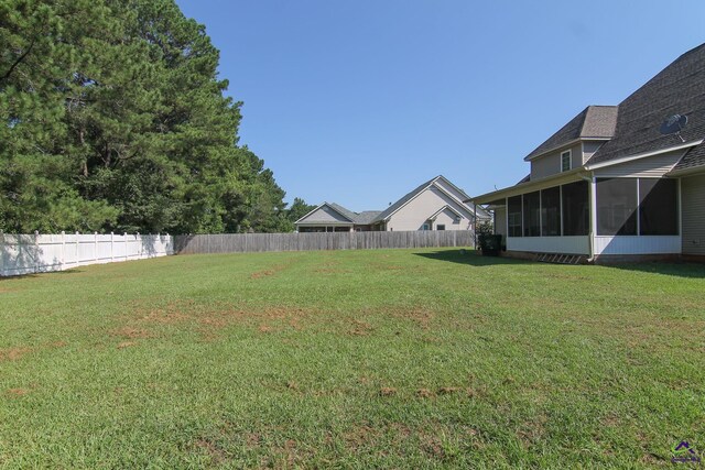view of yard with a sunroom and a fenced backyard