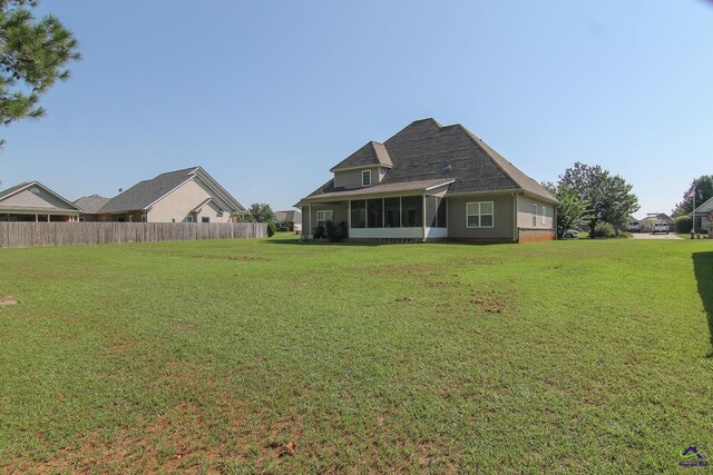 back of house with a yard, fence, and a sunroom