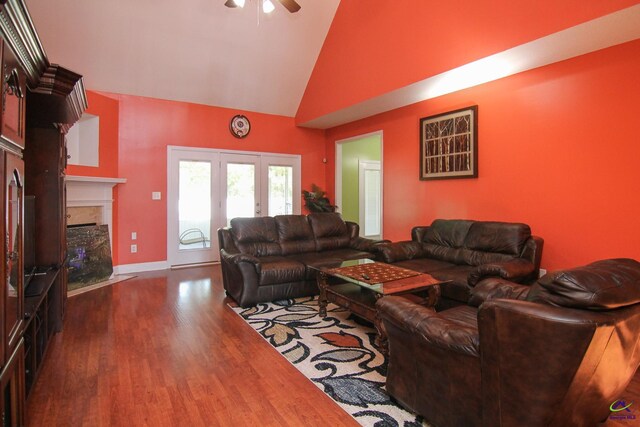 living room with a fireplace, dark wood-type flooring, ceiling fan, high vaulted ceiling, and baseboards
