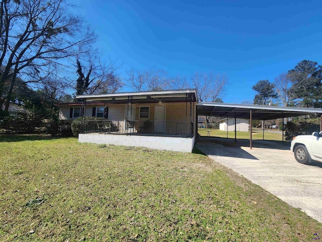 view of front facade featuring a carport, a front yard, covered porch, and driveway