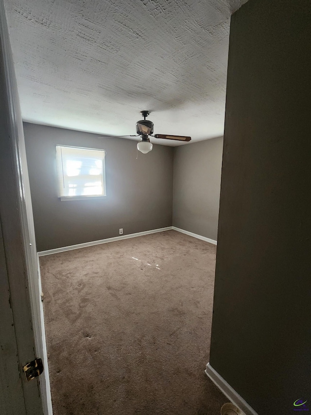 spare room featuring a ceiling fan, carpet, baseboards, and a textured ceiling