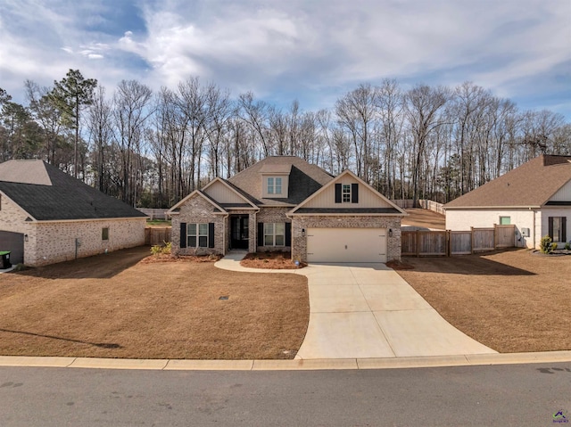 view of front of property with an attached garage, brick siding, fence, concrete driveway, and a front lawn