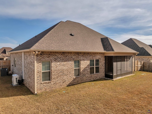 back of property with a yard, brick siding, cooling unit, and a sunroom