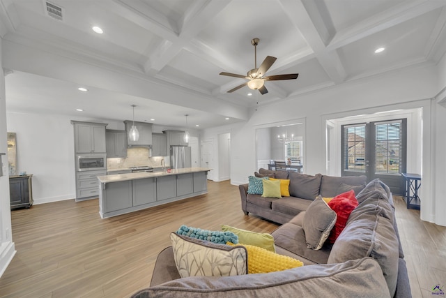 living area with light wood finished floors, coffered ceiling, beam ceiling, and visible vents