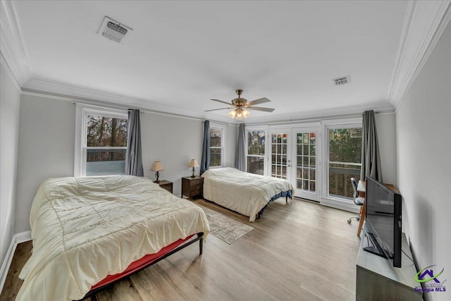 bedroom featuring french doors, multiple windows, wood finished floors, and visible vents