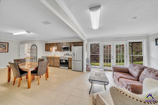 dining room featuring a textured ceiling, light tile patterned floors, visible vents, ornamental molding, and french doors