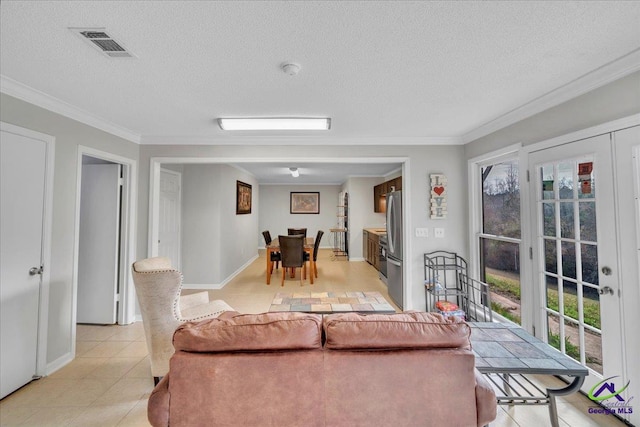 living area featuring baseboards, visible vents, a textured ceiling, and ornamental molding