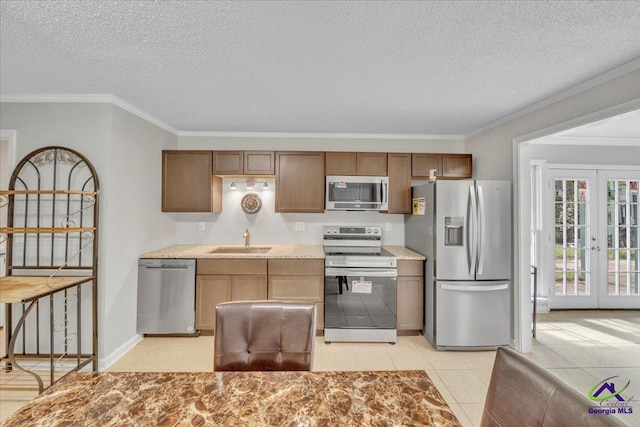 kitchen featuring stainless steel appliances, french doors, a sink, and crown molding