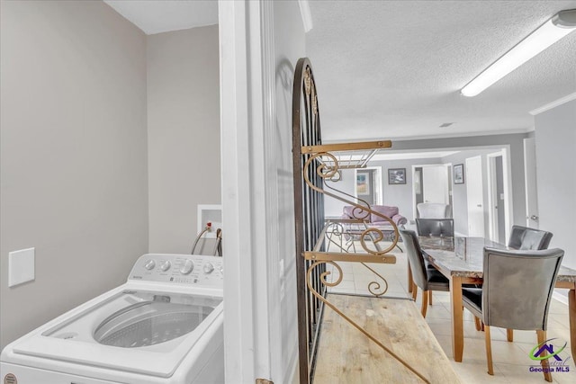 laundry room featuring a textured ceiling, laundry area, tile patterned flooring, and washer / dryer