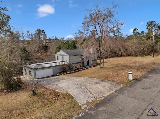 view of front of home featuring driveway, an attached garage, and a front yard