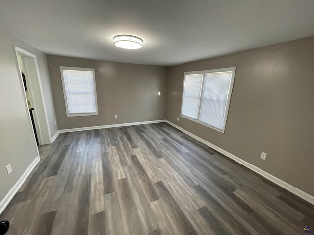 unfurnished room featuring dark wood finished floors and baseboards