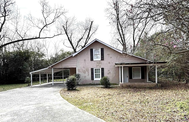 view of front of property with a carport, aphalt driveway, and a porch