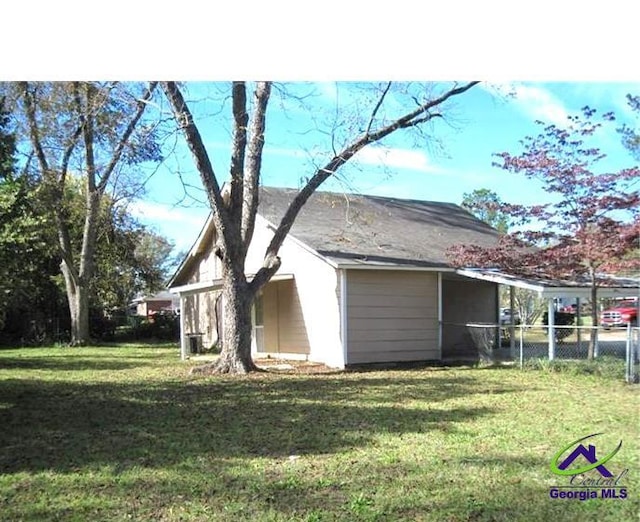 view of property exterior with fence and a lawn