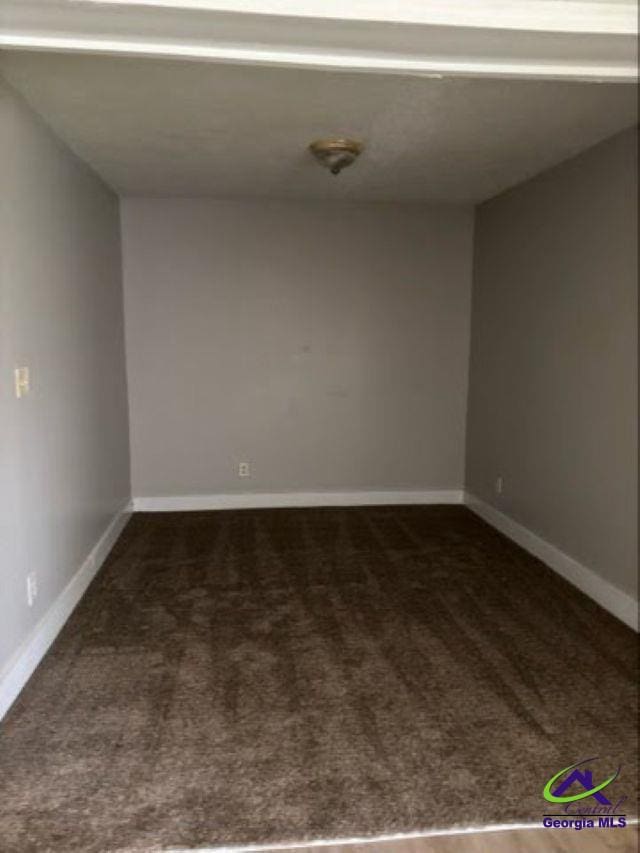 empty room featuring carpet floors and baseboards