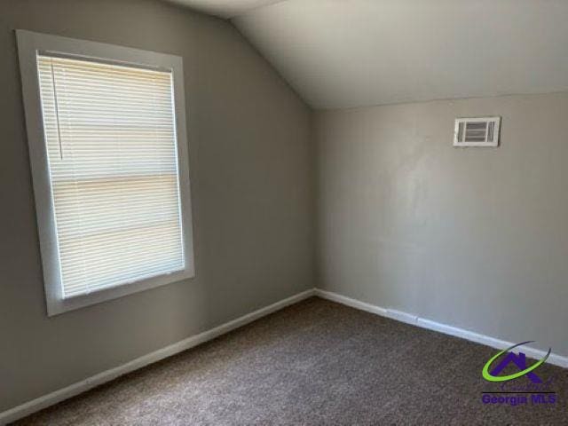 bonus room featuring lofted ceiling, visible vents, and baseboards