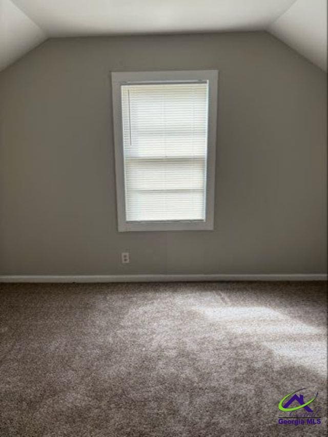 bonus room featuring lofted ceiling, carpet floors, and baseboards