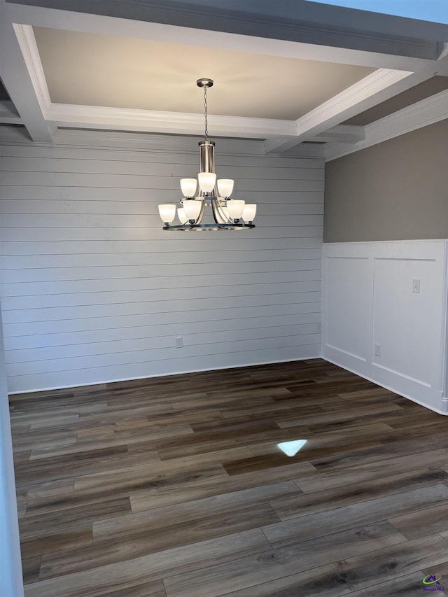 unfurnished dining area with dark wood-style floors, crown molding, and a notable chandelier