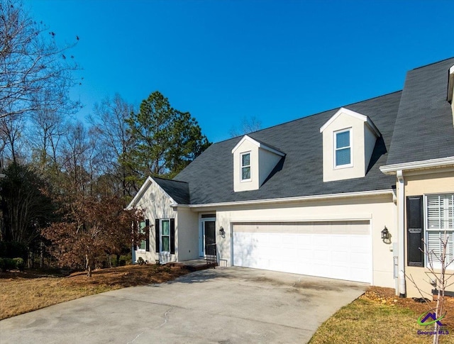 view of front of house with an attached garage, concrete driveway, and stucco siding