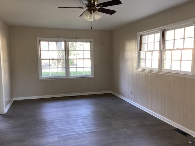 unfurnished room featuring a ceiling fan, baseboards, visible vents, and dark wood-type flooring