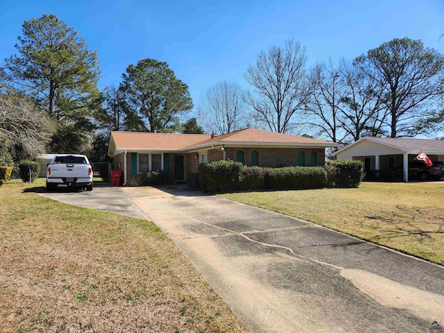 ranch-style home featuring driveway, brick siding, and a front yard