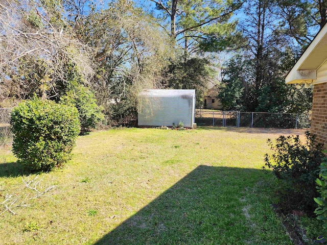 view of yard featuring a storage unit, fence, and an outdoor structure