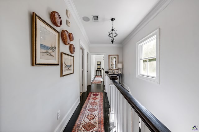 hall with an upstairs landing, baseboards, visible vents, dark wood finished floors, and crown molding