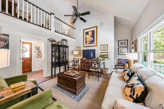 living area featuring visible vents, a ceiling fan, wood finished floors, high vaulted ceiling, and baseboards