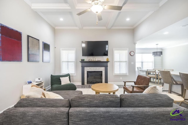 living room featuring baseboards, coffered ceiling, a glass covered fireplace, crown molding, and beam ceiling