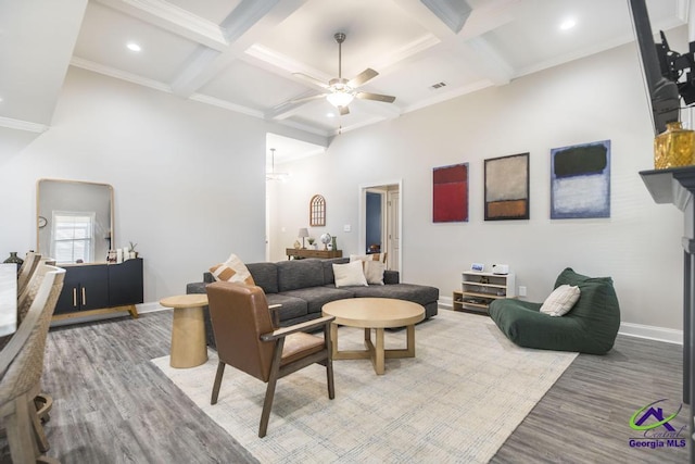 living area featuring a ceiling fan, baseboards, a high ceiling, and wood finished floors