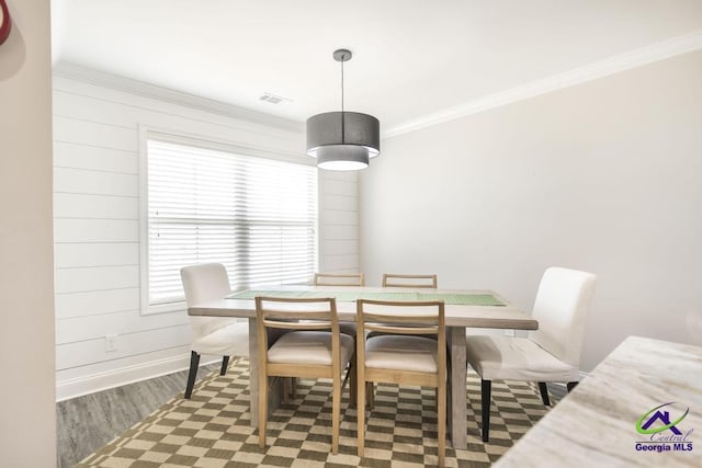 dining area with a healthy amount of sunlight, crown molding, baseboards, and wood finished floors