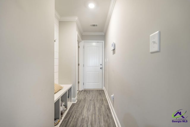 mudroom featuring ornamental molding, wood finished floors, visible vents, and baseboards