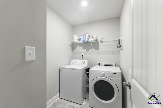 laundry area featuring laundry area, marble finish floor, baseboards, and separate washer and dryer