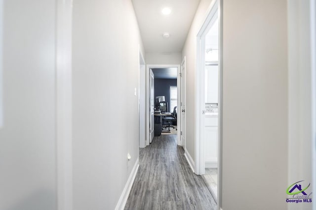 hall featuring light wood-type flooring and baseboards