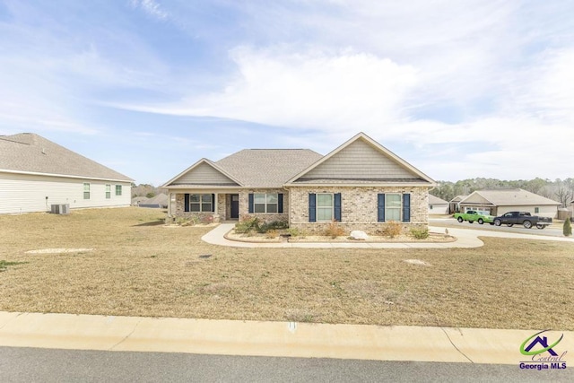 craftsman-style home featuring a front lawn, central AC, and brick siding