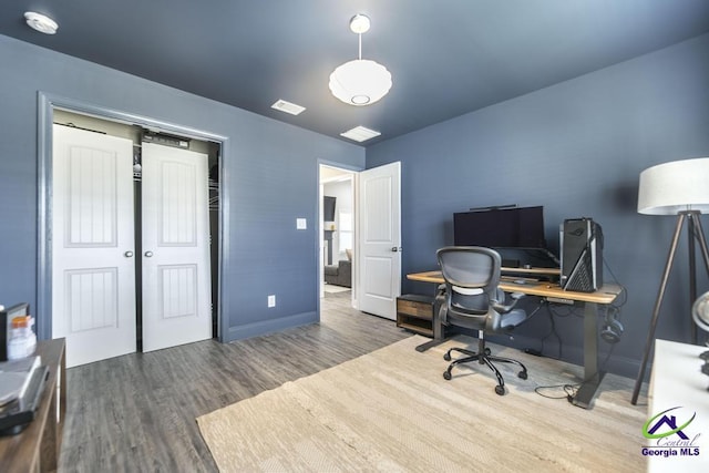 office space with visible vents, baseboards, and wood finished floors