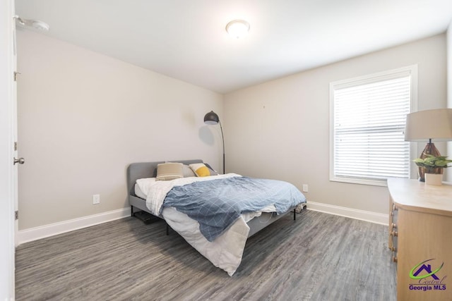 bedroom featuring baseboards and wood finished floors