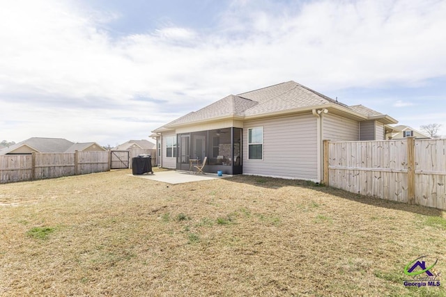 rear view of house featuring a patio, a fenced backyard, a sunroom, roof with shingles, and a lawn