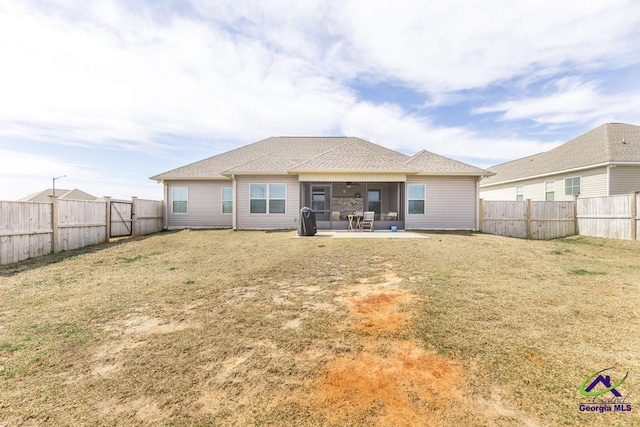 rear view of property featuring a patio area, a fenced backyard, and a yard