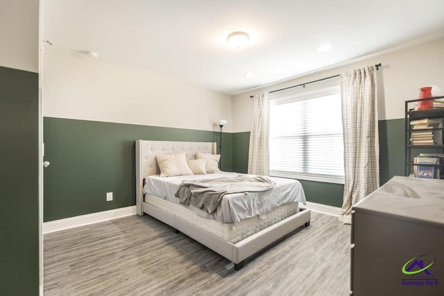 bedroom with baseboards and wood finished floors