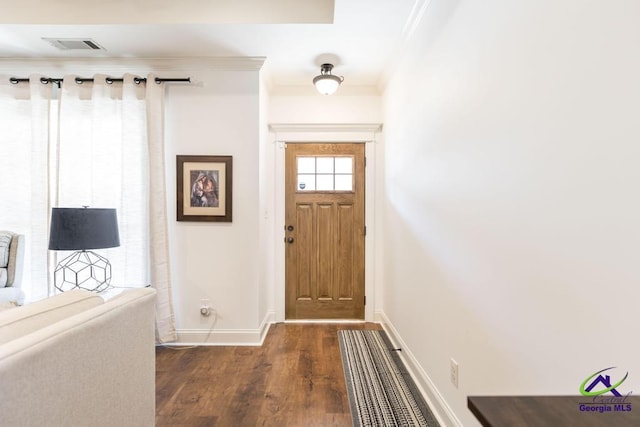 entrance foyer with ornamental molding, dark wood-style flooring, visible vents, and baseboards