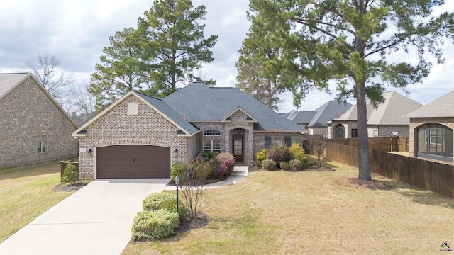 view of front of house featuring brick siding, an attached garage, fence, driveway, and a front lawn