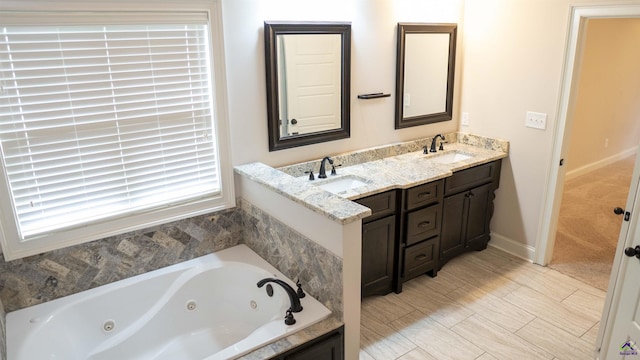 full bathroom with a whirlpool tub, double vanity, and a sink