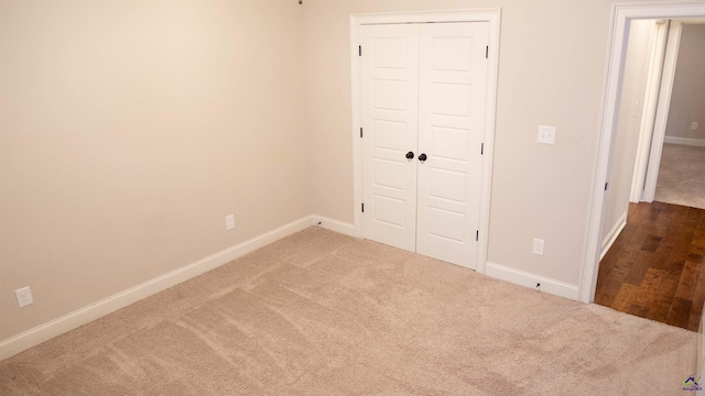 unfurnished bedroom with carpet floors, baseboards, and a closet