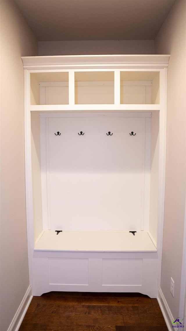 mudroom featuring dark wood finished floors and baseboards