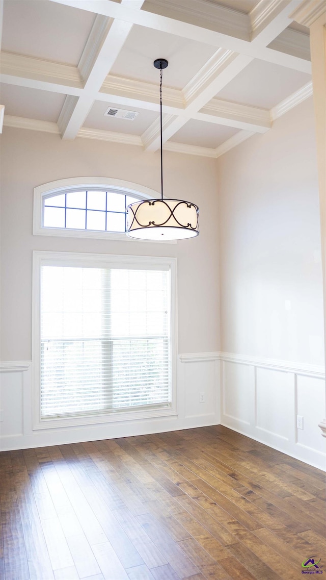 empty room with dark wood-style floors, visible vents, beamed ceiling, and coffered ceiling