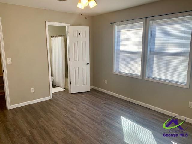 unfurnished bedroom featuring ceiling fan, baseboards, and dark wood finished floors