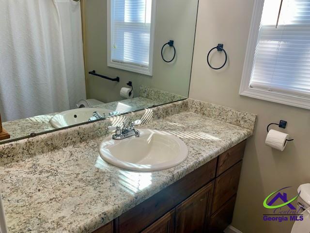 full bath featuring vanity and toilet