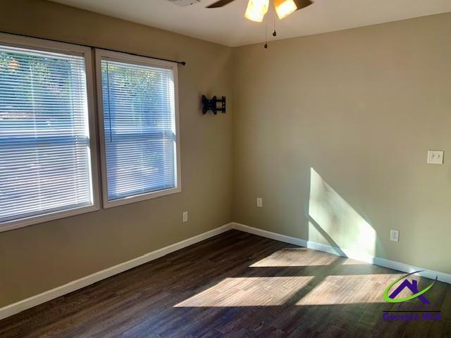 spare room with a ceiling fan, baseboards, and wood finished floors