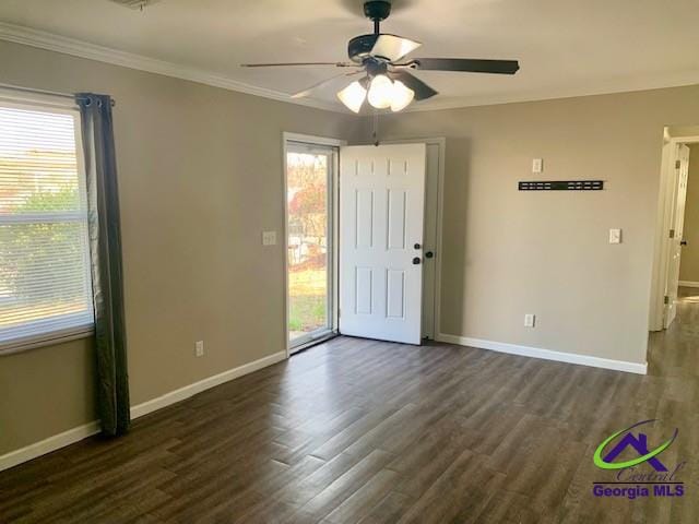 spare room featuring ornamental molding, dark wood-type flooring, and baseboards