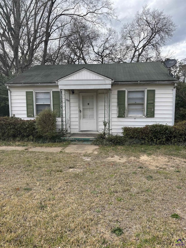 bungalow-style home with a front yard